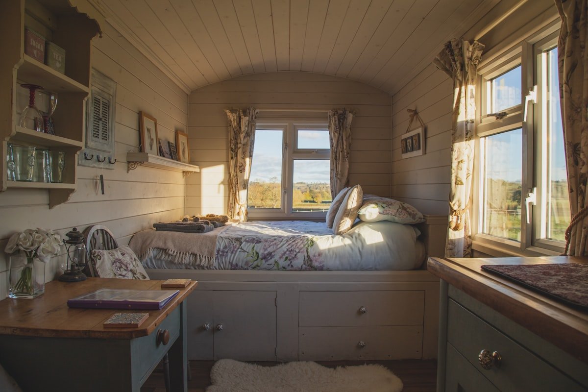 Apartment bedroom with bed beside a bright window