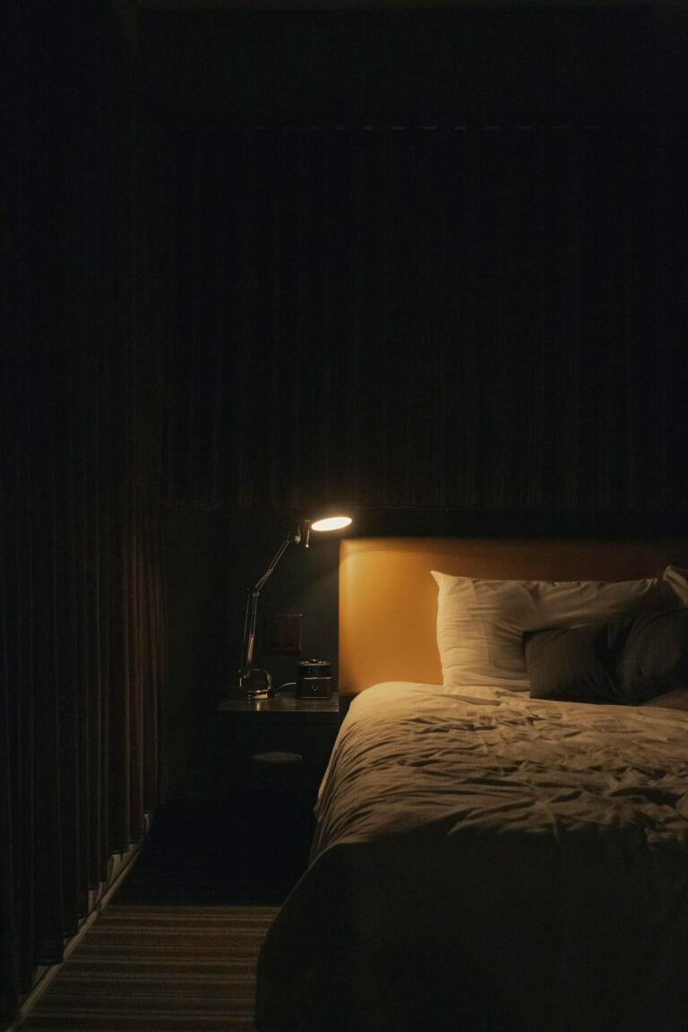 Cozy apartment bedroom with warm bedside lamp lighting