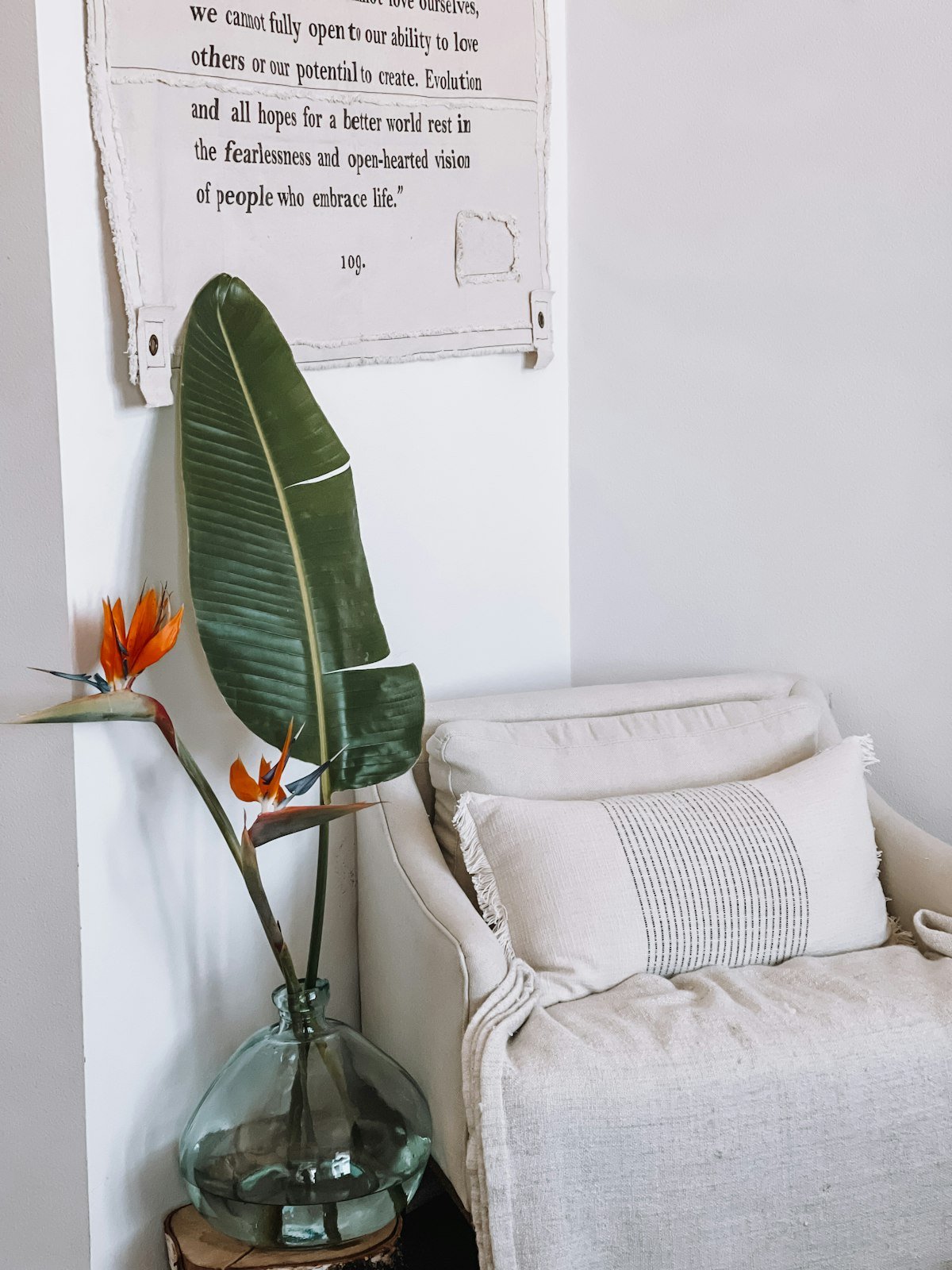Simple reading nook with a chair and a vase of greenery