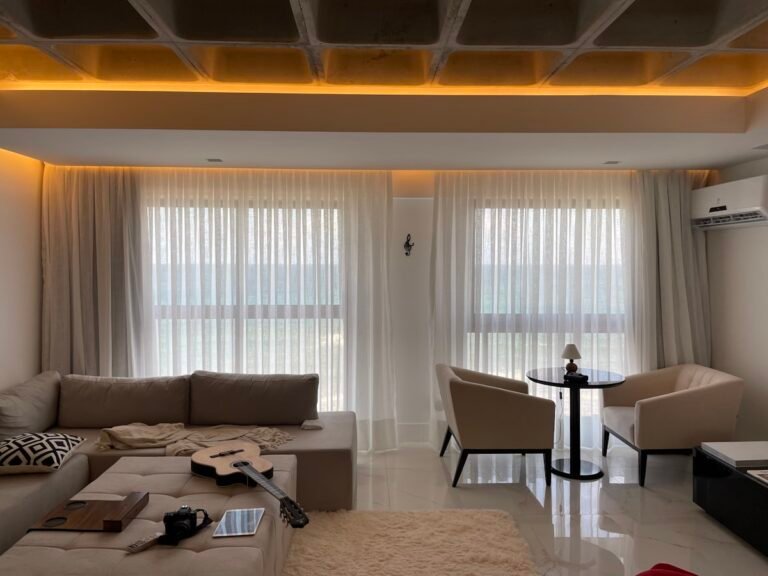 Studio apartment living zone with neutral sofa and layered textures