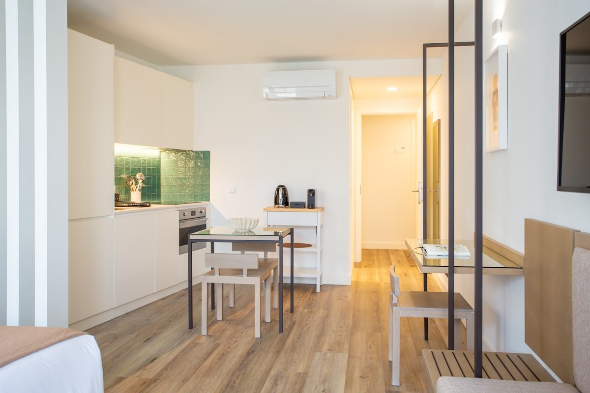 Studio apartment room zoned for dining, lounging and TV