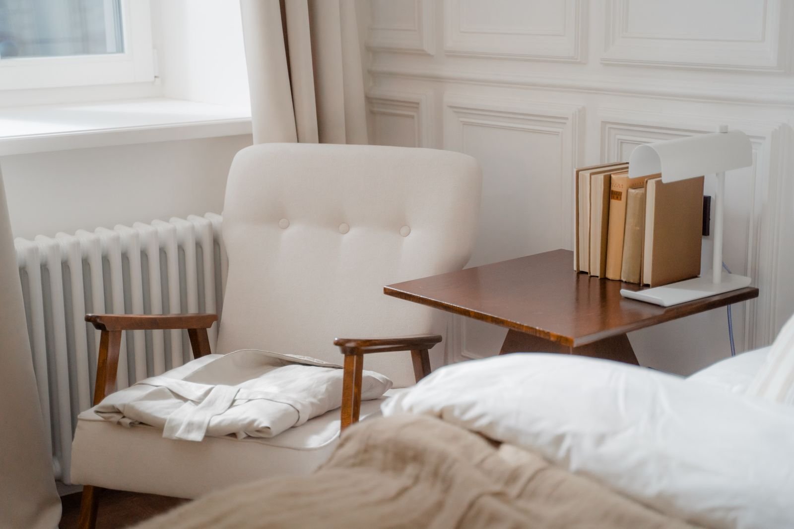 Simple reading nook with an armchair, side table and a stack of books