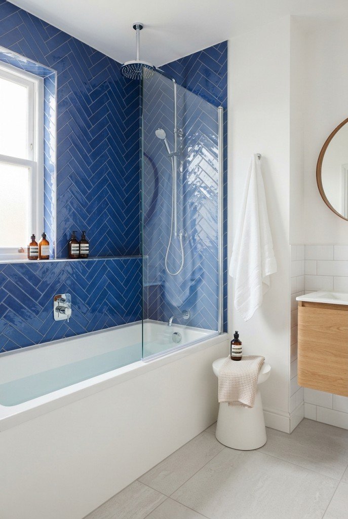 Cobalt blue herringbone tile shower wall with a white tub