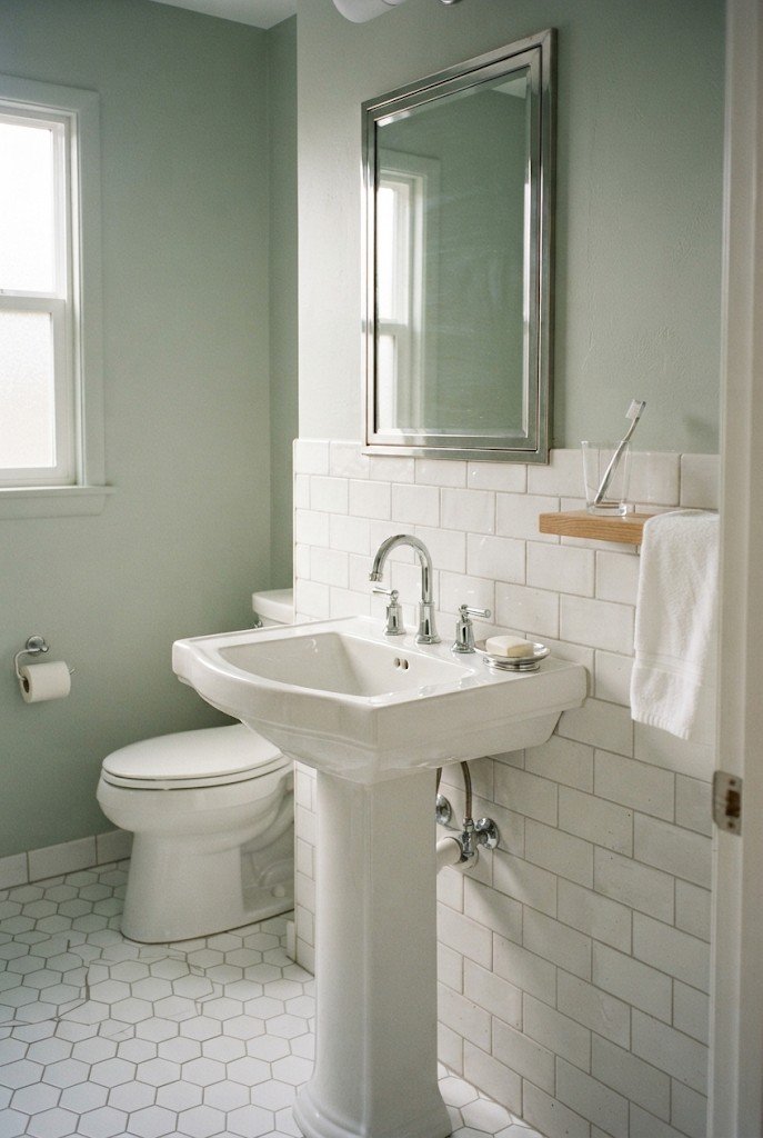 White pedestal sink with a recessed mirrored medicine cabinet in a small bathroom