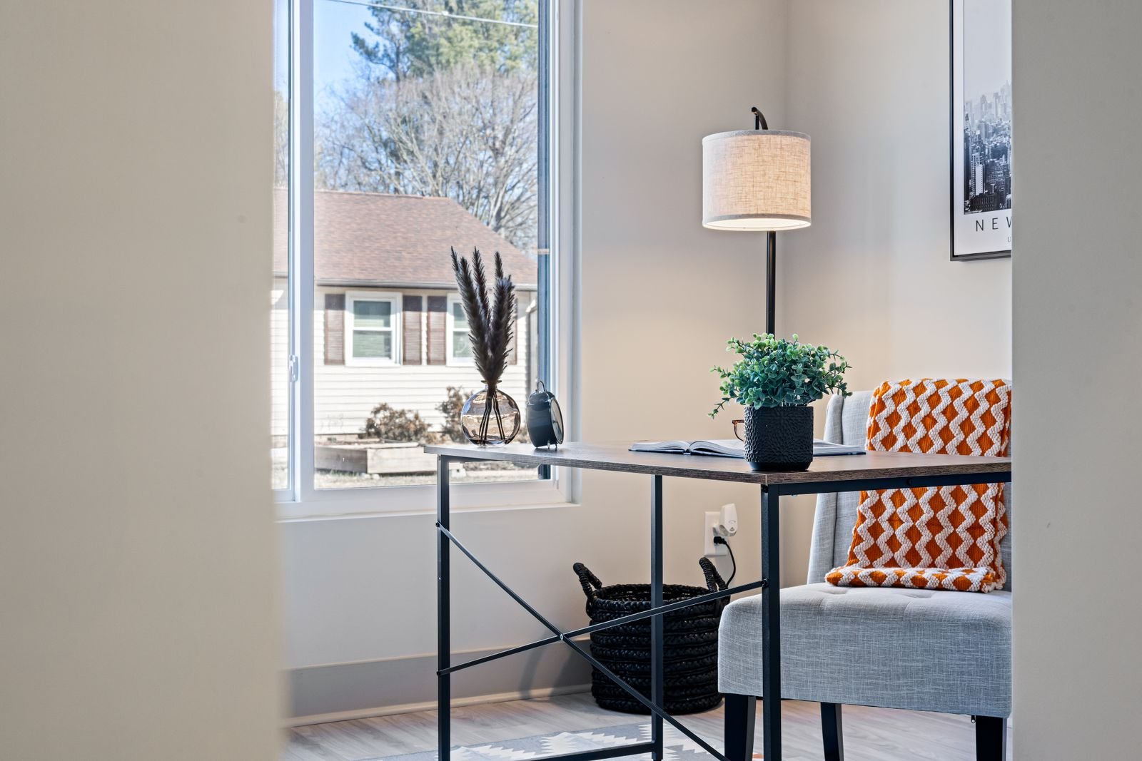 Cozy desk corner by a window with a small lamp in an apartment