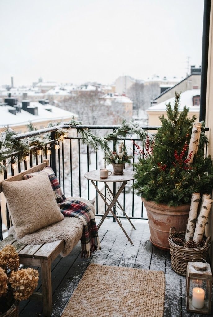 Winter apartment balcony with a potted dwarf pine with berries, birch logs, light snow and a cushioned wooden bench