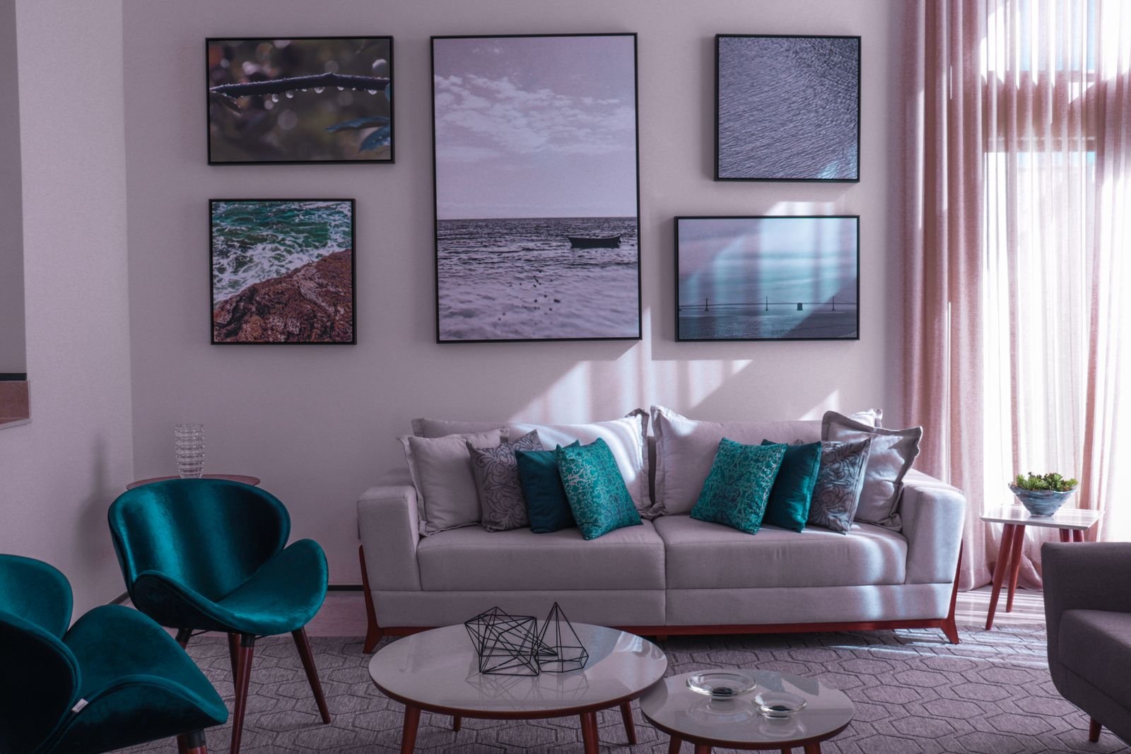 Collection of framed artwork displayed above a sofa in an apartment