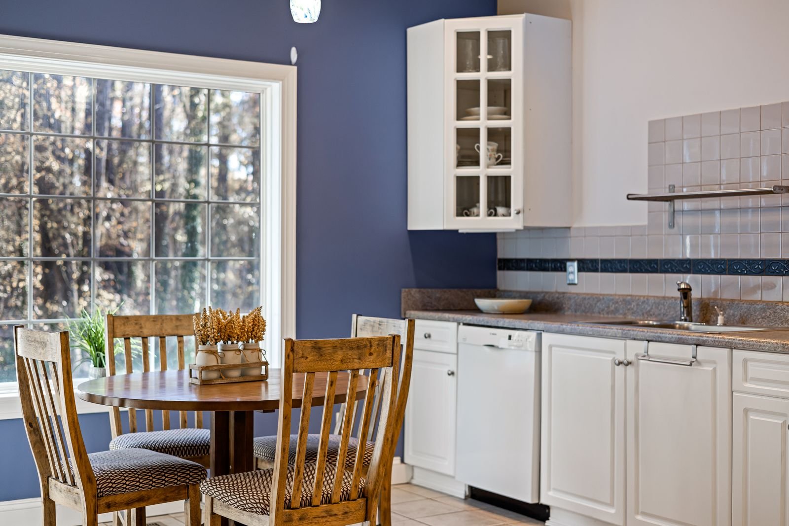 Compact kitchen dining nook with a wooden table beside a bright window