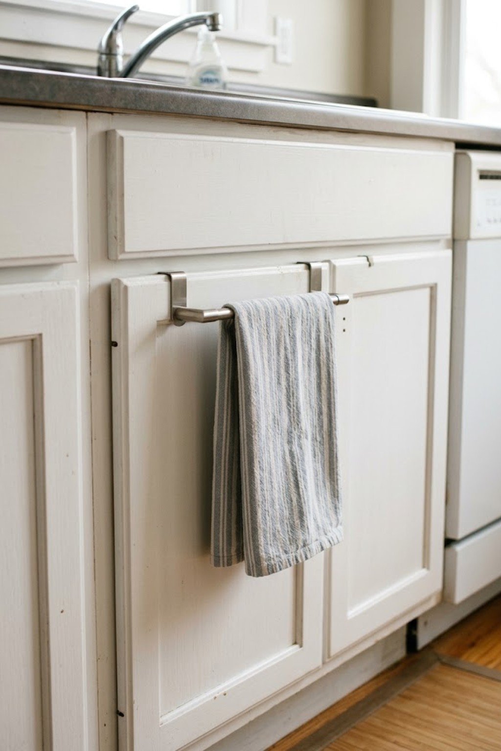 Over-cabinet towel bar with a dish towel on a kitchen cabinet