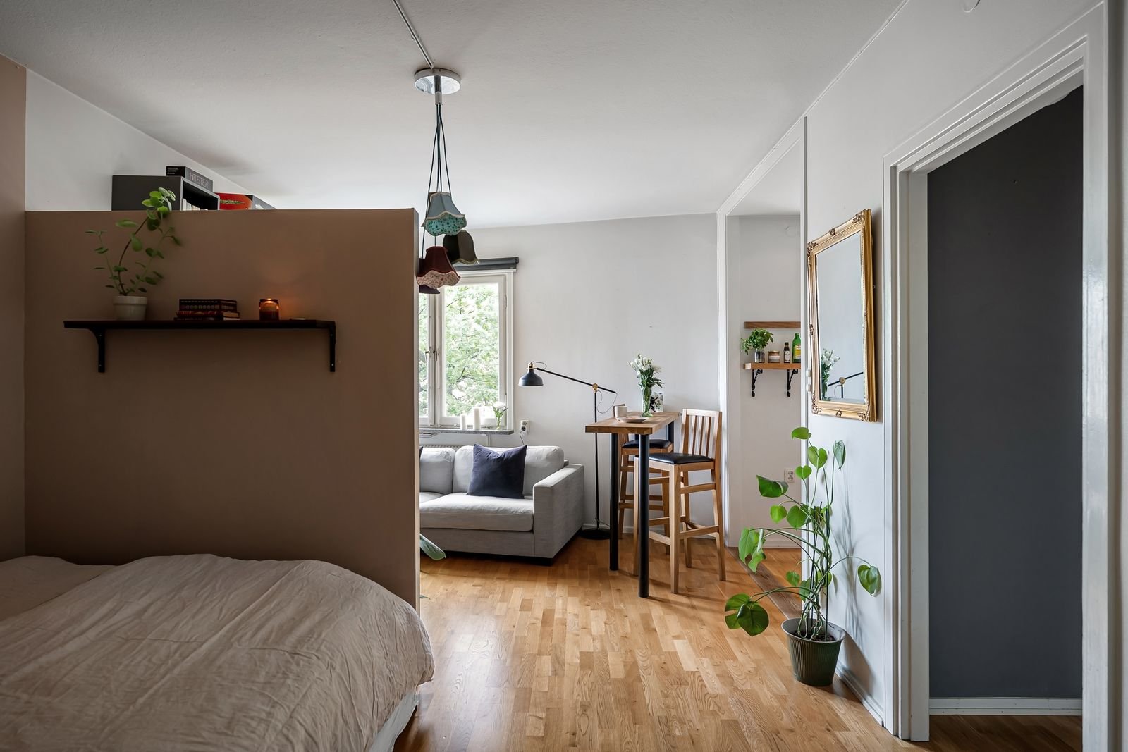 Small studio apartment zoned into sleeping, living and dining areas