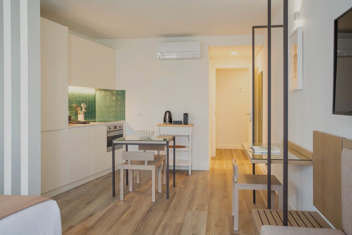 Studio apartment room zoned for dining, lounging and TV