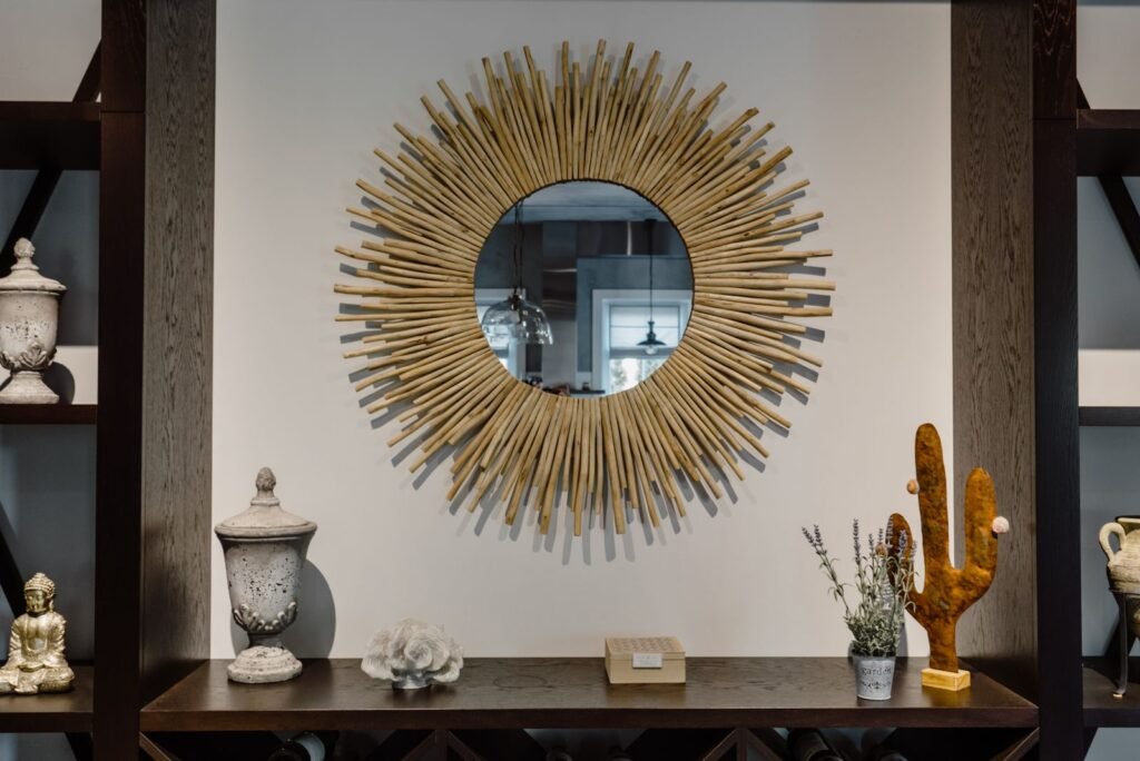 Gold sunburst mirror over a styled console with thrifted vases and decor that look high-end