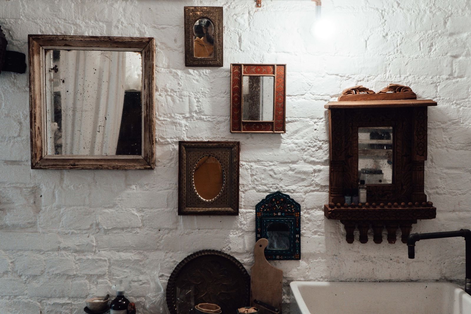 Thrifted vintage mirrors and frames arranged as an eclectic gallery wall