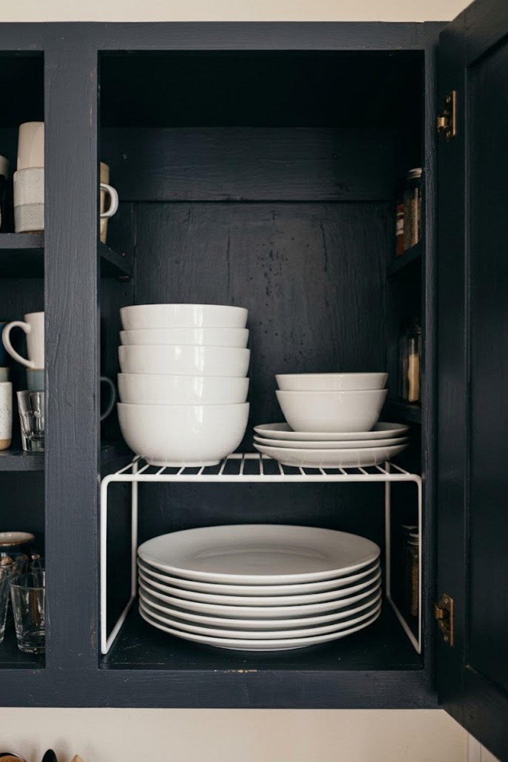 Shelf risers doubling space inside a kitchen cabinet